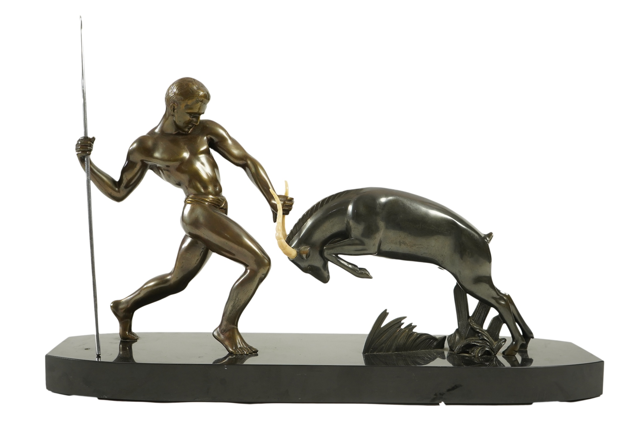 Attributed to Zoltan Kovasz (Romanian, 1883-1952), a bronzed spelter male hunter holding a chromed spear, with springbok, on a polished slate base